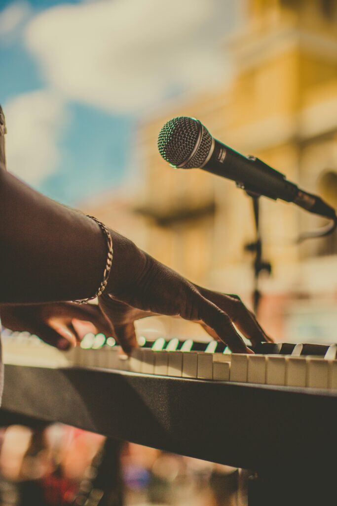 Musician playing piano and singing with a microphone outdoors in San Juan.